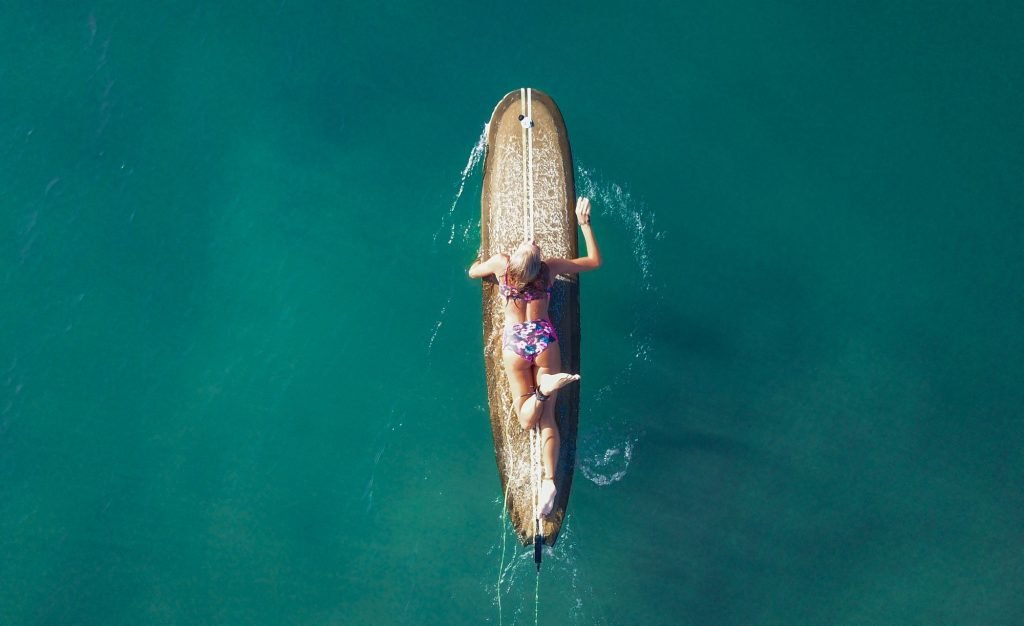 female surfer floating on surfboard in sea