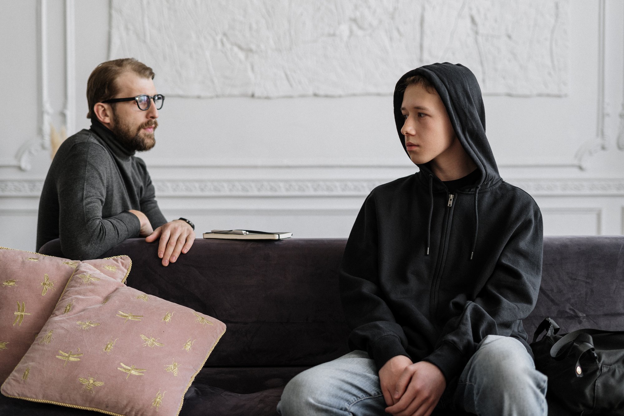 therapy session with a teenager wearing a black hoodie|