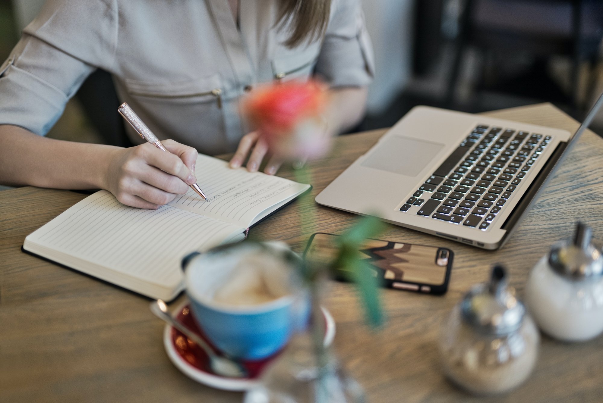 woman writing on a journal in her desktop