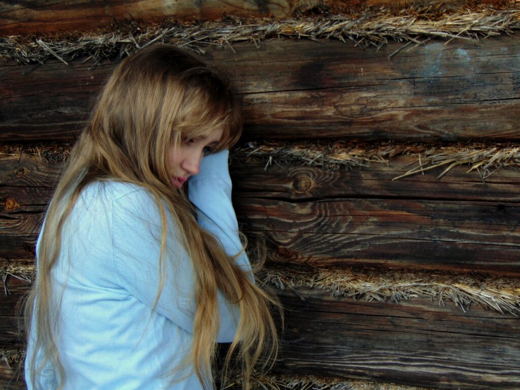 A female teen holding her head up against the wall, after having a panic attack; is in clear need of treatment. 