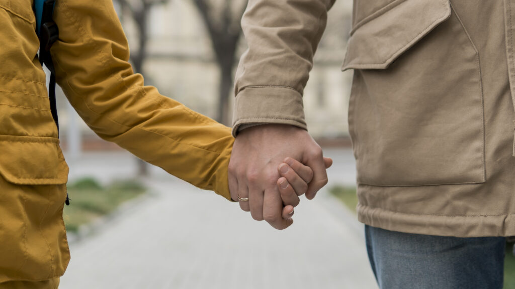 A female teen is holding hands with her father after fully recovering from drug addiction. 