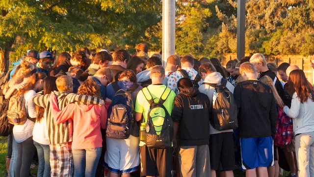 A group of teens bowing their heads as they engage in prayer; they learned that pinning their faith to a deity can help with any drug problems that they may have.