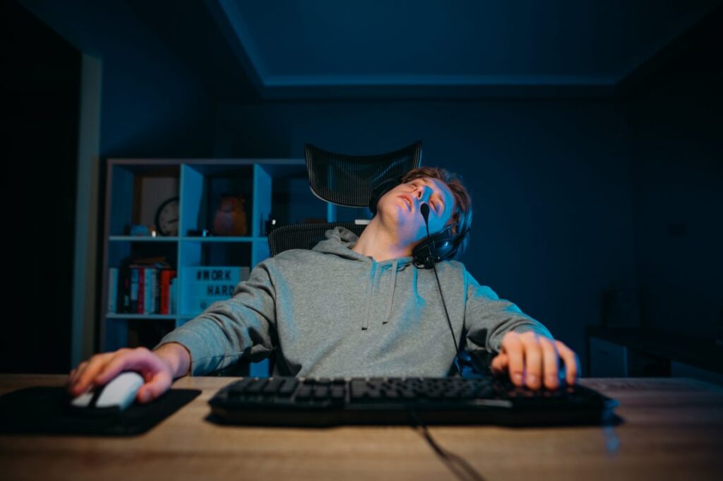 Male teen falling asleep playing computer games and it's affecting his neck. In clear need of treatment. 