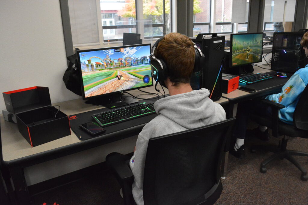 2 male teens playing computer games at school, rather than working on their homework. In clear need of treatment. 