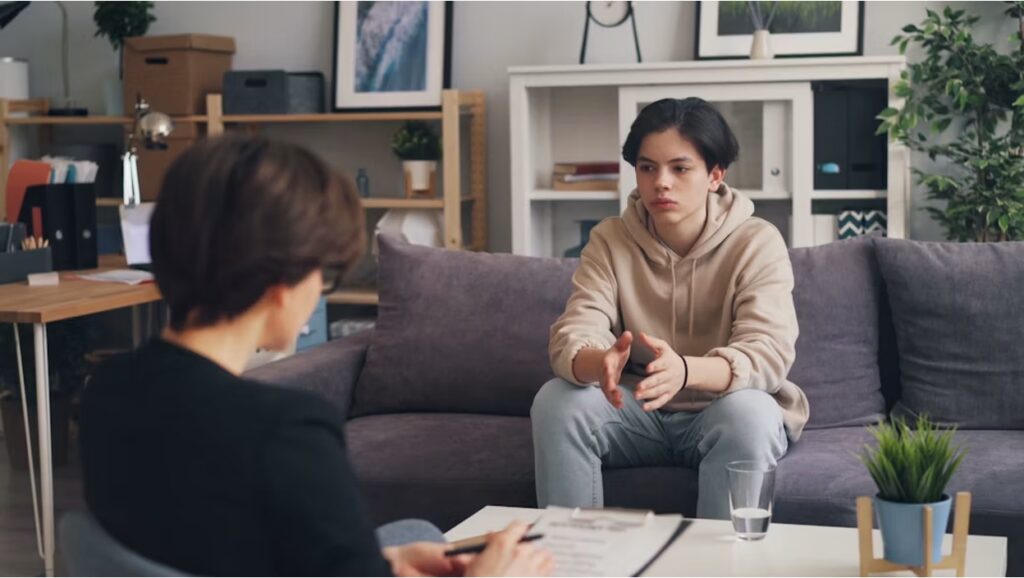 A young teen boy in a therapy session in a calm, soothing home-like environment.