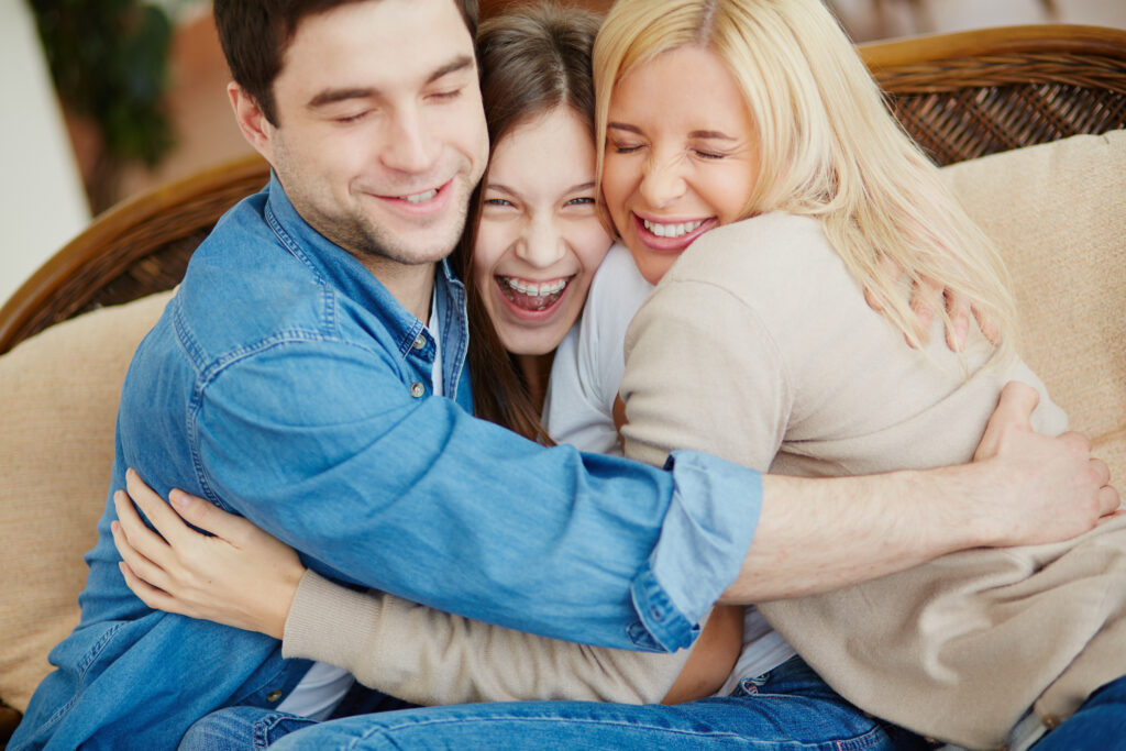 A young family hugging after a therapy session here at Clearfork Academy.