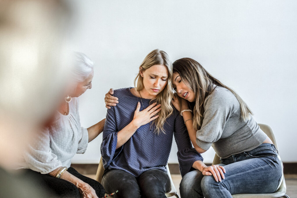 A young family hugging at one of their sessions with a therapist here at Clearfork Academy.