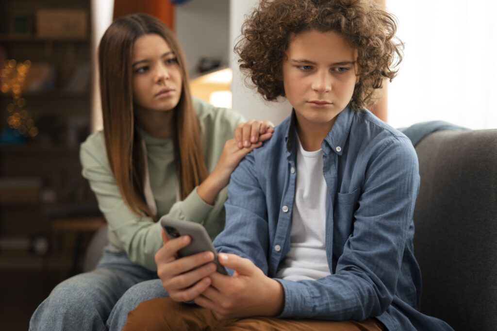 A male teen is being cyberbullied and his female friend is concerned. 
