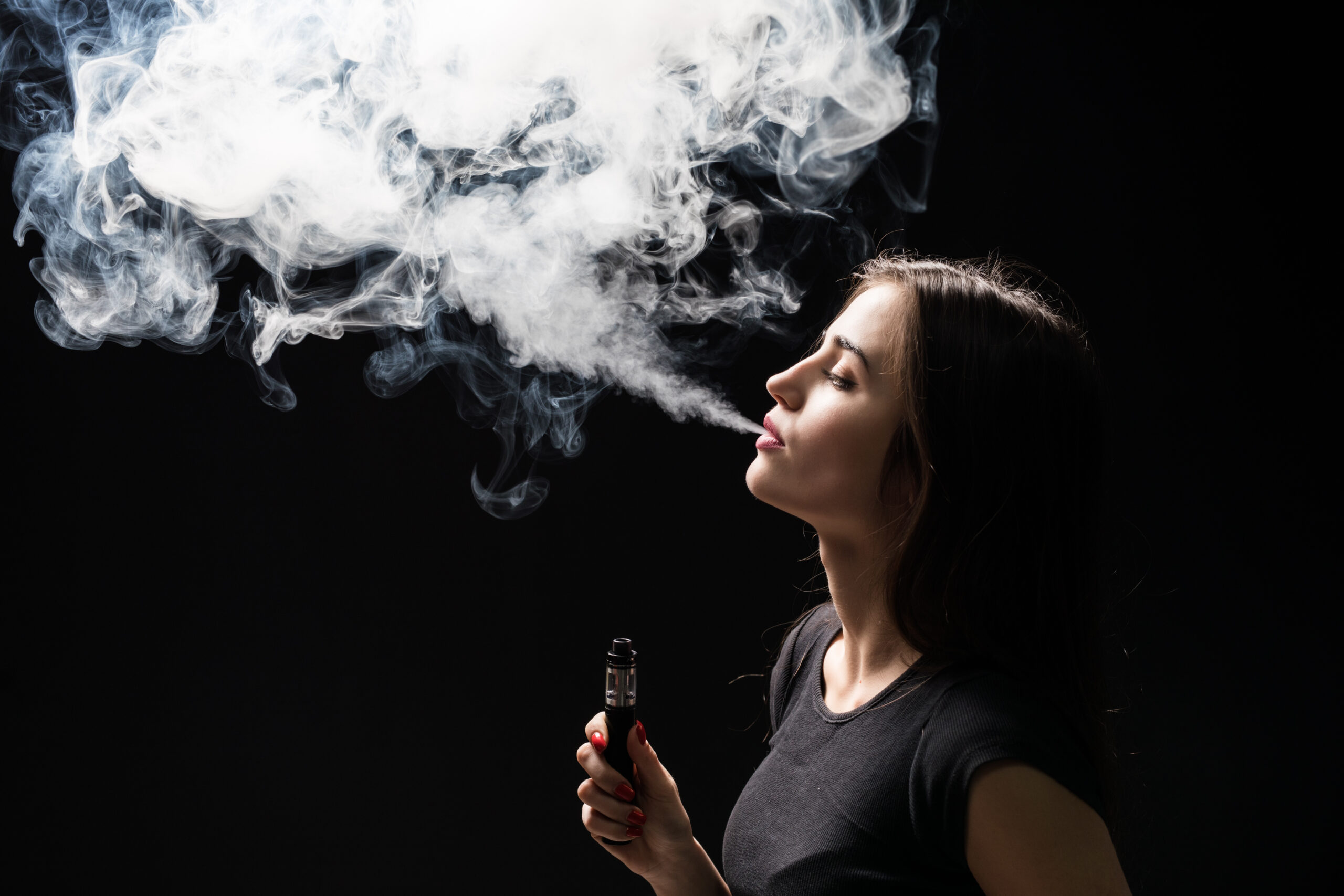 A young female teen vaping while at school.