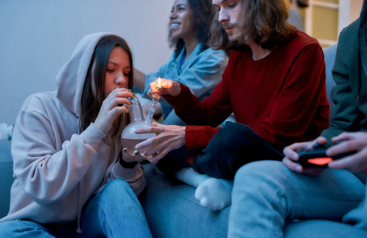Teens smoking weed out of a bong; in need of treatment for THC dependency.