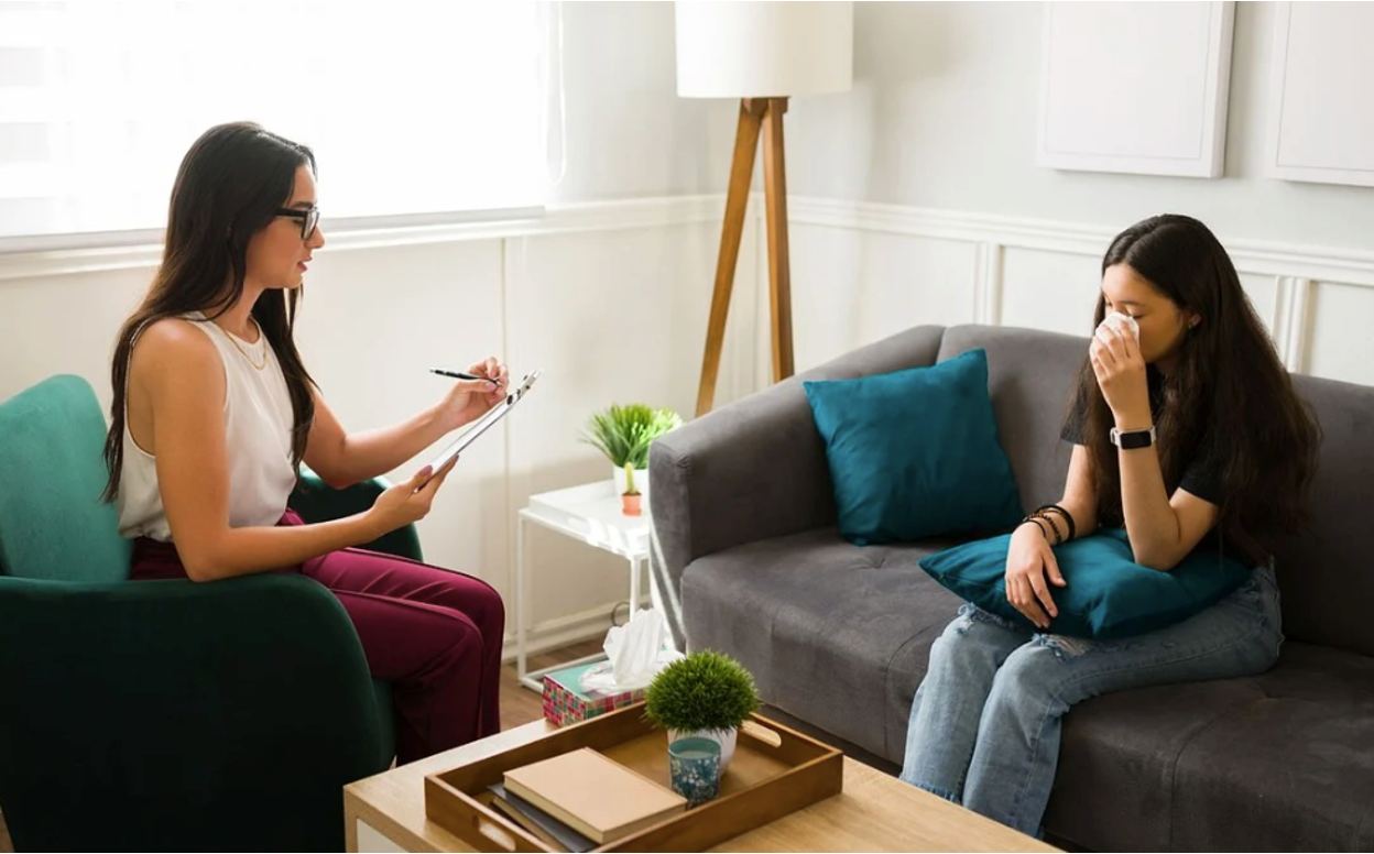 A therapist helping a teenager work through their mental health issues using CBT
