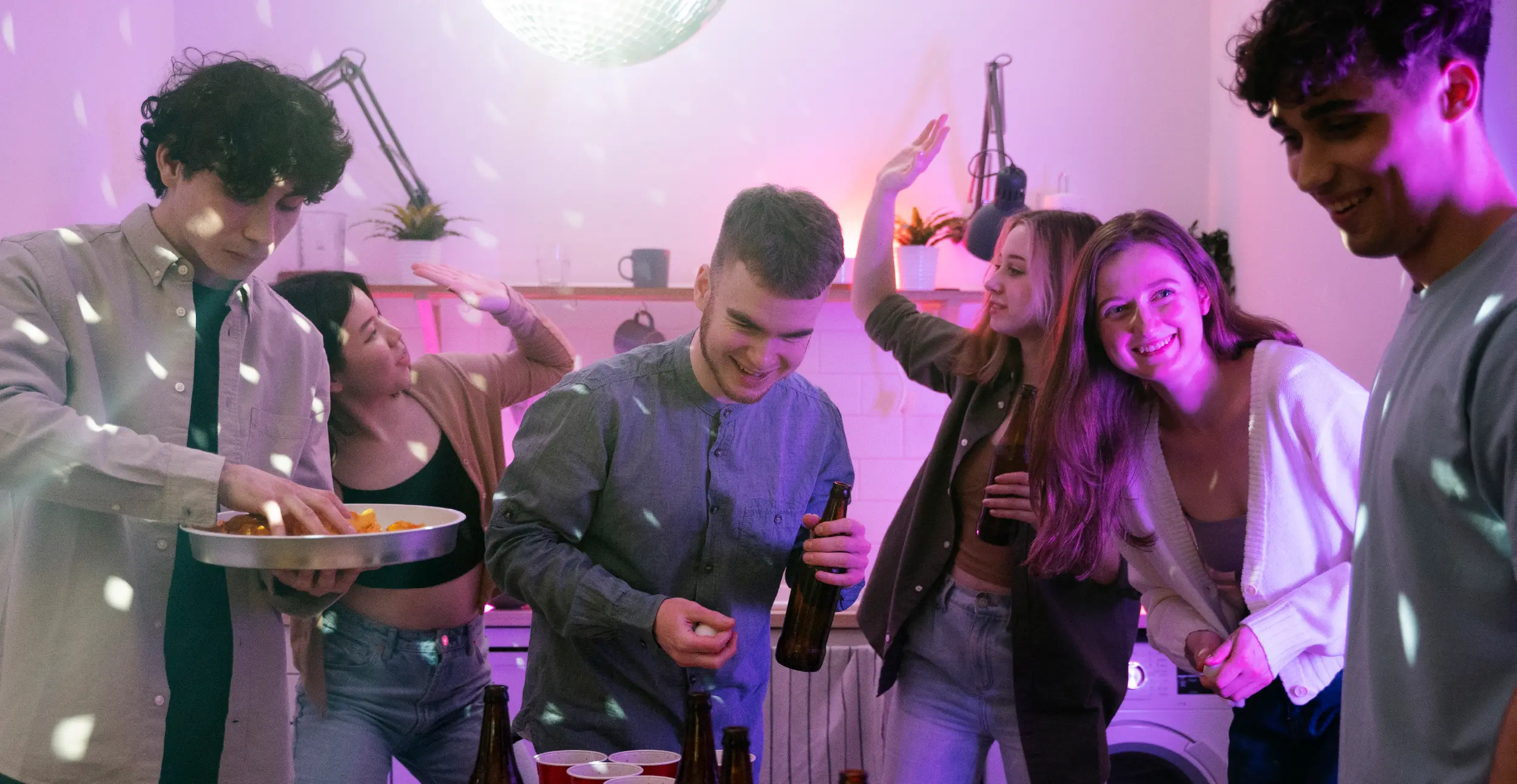 Teenagers at a party with beer bottles and red cups, highlighting common social settings where underage drinking may occur.