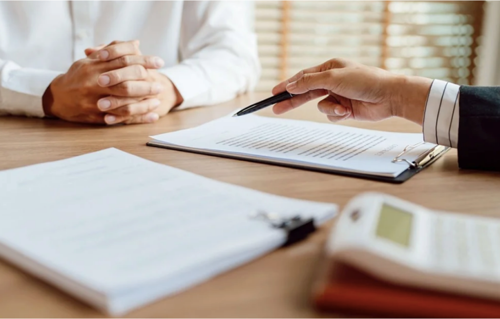 A parent signing a document after deciding to send their teen to rehab. 
