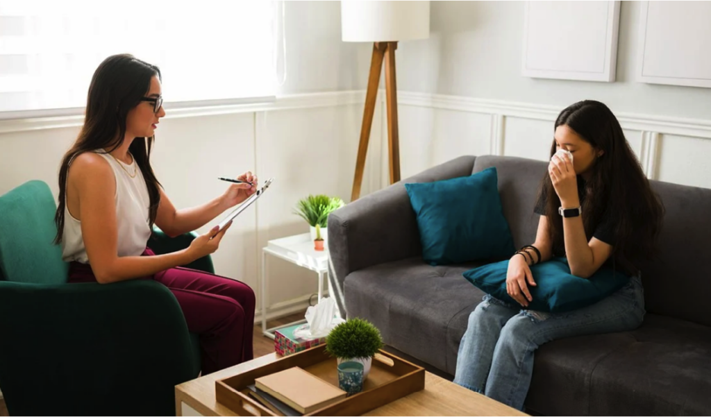 Teen in a therapy session with a counselor, working through opioid addiction treatment