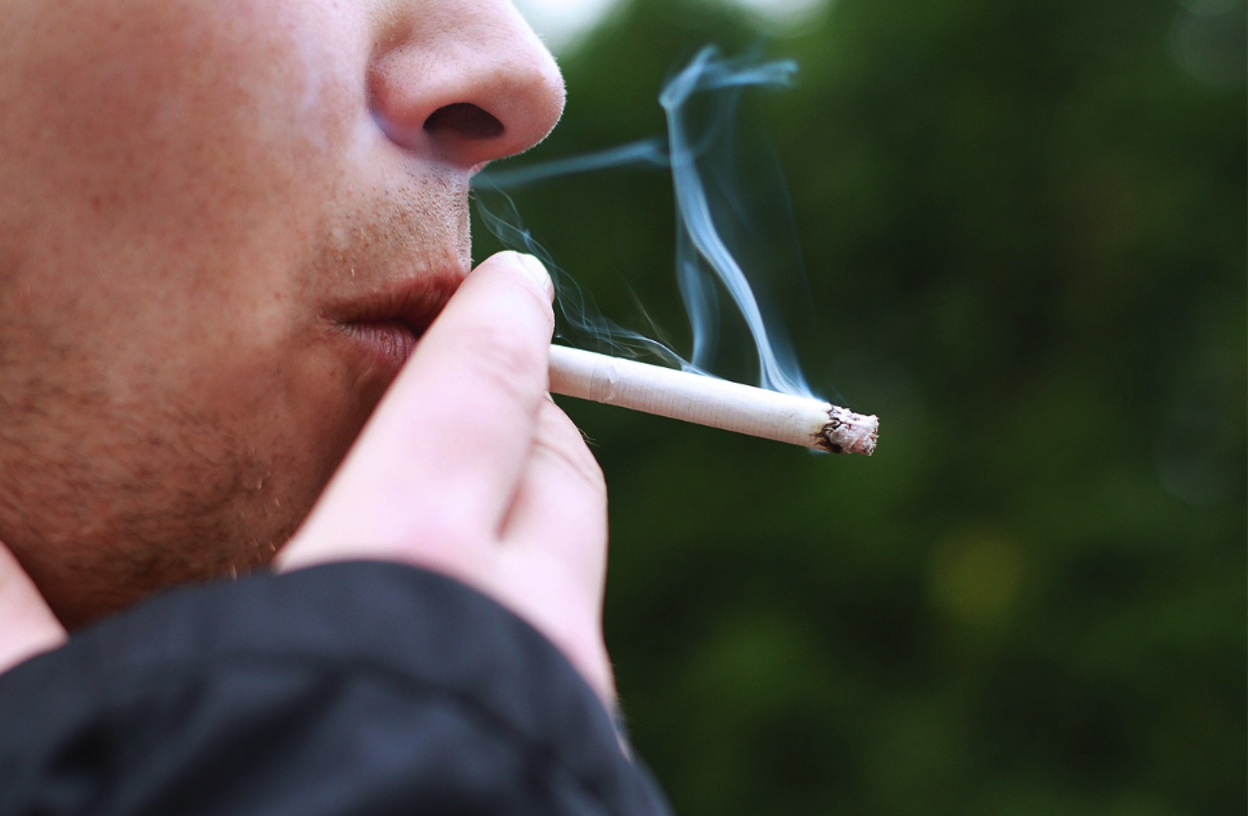 een smoking marijuana outdoors, illustrating adolescent cannabis use and addiction risk