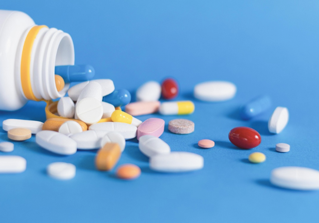 A bottle of prescription blood pressure pills spilled out on a table