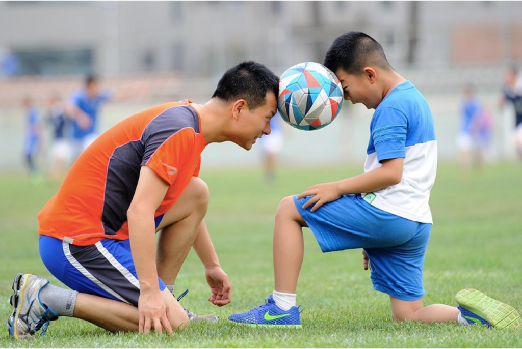 A child playing football with their parent to support healthy recovery