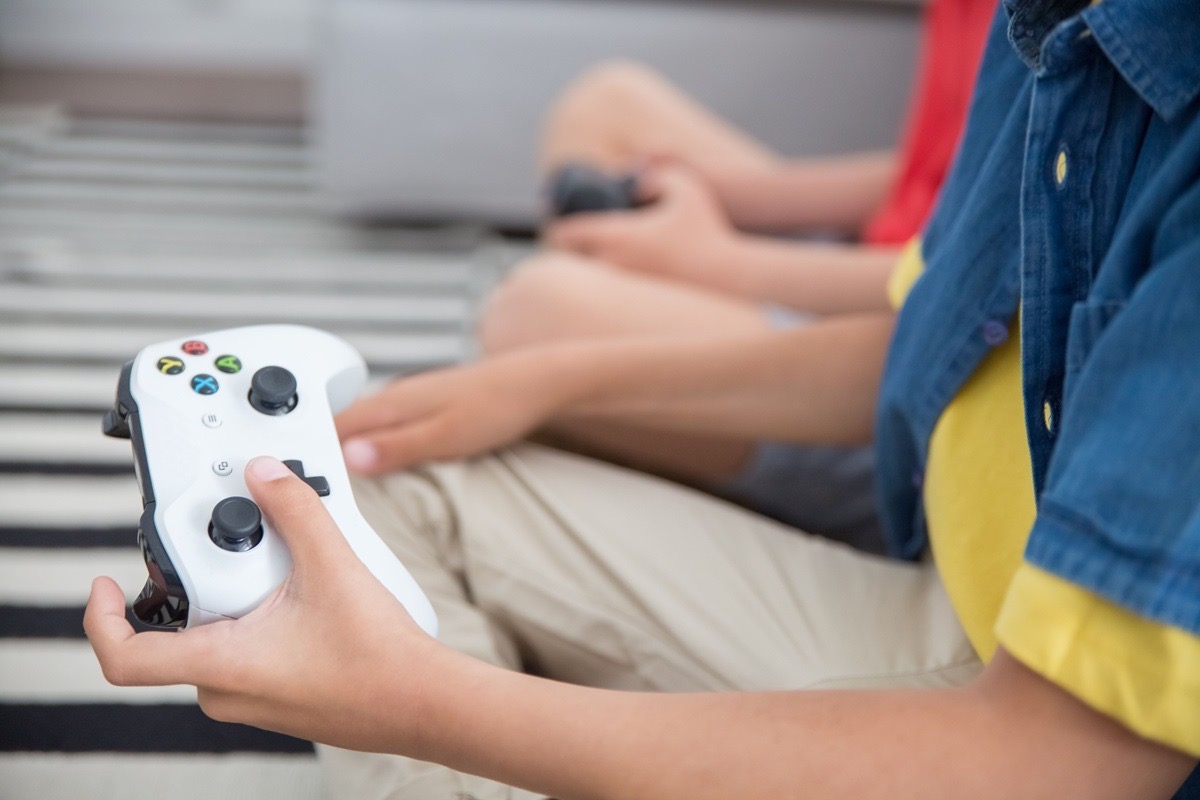 A child holding a gaming controller, showing the compulsive gaming patterns parents watch for in their kids
