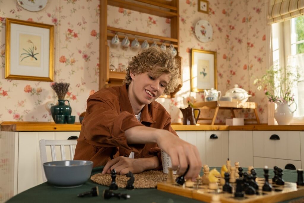A teenager playing chess at home in a calm, structured environment