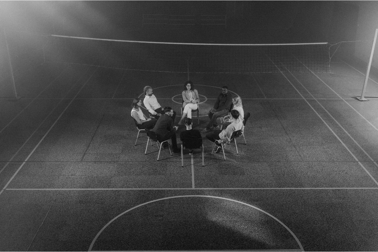 Group therapy session conducted in a sports hall