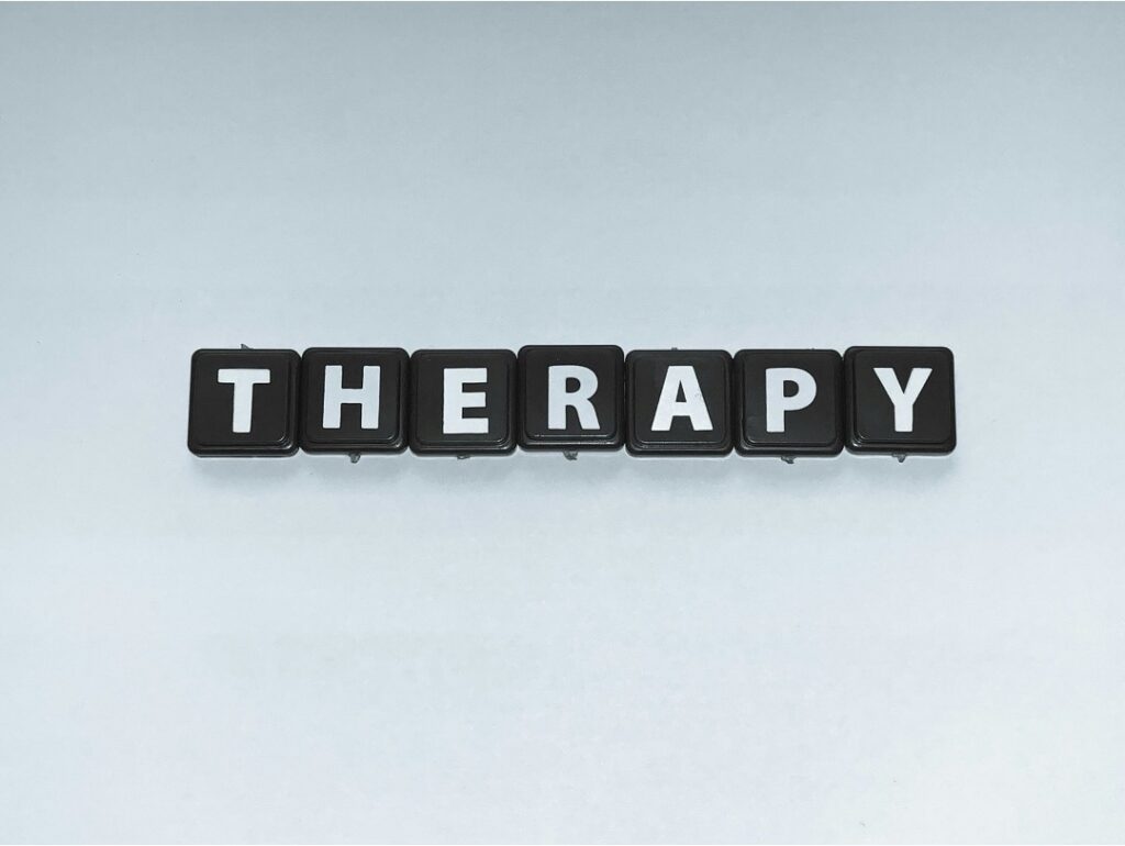 “Therapy” spelled out with black individual letter tiles