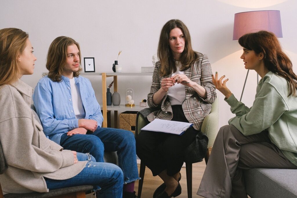 Teen and family members in a therapy session with a female counselor