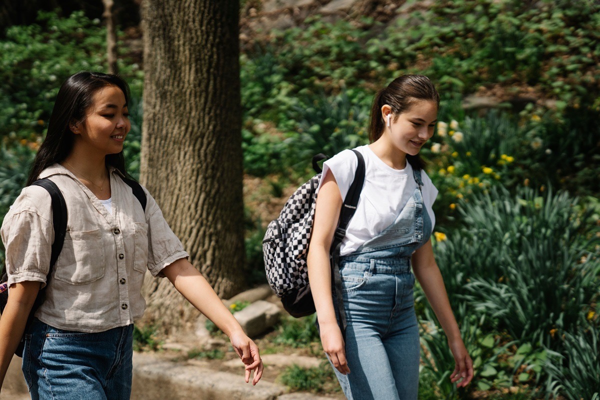 Two teenage girls walking together outdoors, representing peer connection and everyday life during teen rehab recovery near Irving