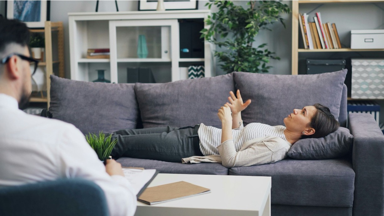Woman undergoing a therapy session with a therapist in a cozy setting