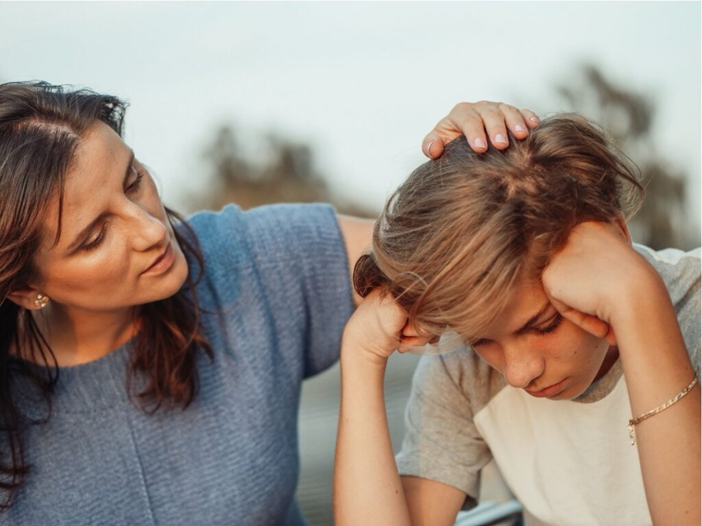 Mother consoling her distressed teenage son during a hard moment that may call for professional support