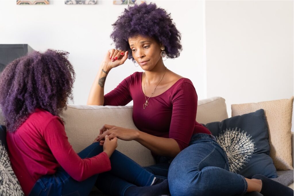 Mother listening closely as her teen daughter shares her OCD triggers during a conversation on the sofa